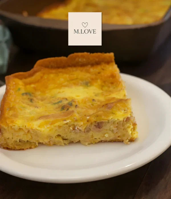 Fatia de quiche caseira com recheio cremoso servida em prato branco sobre mesa escura