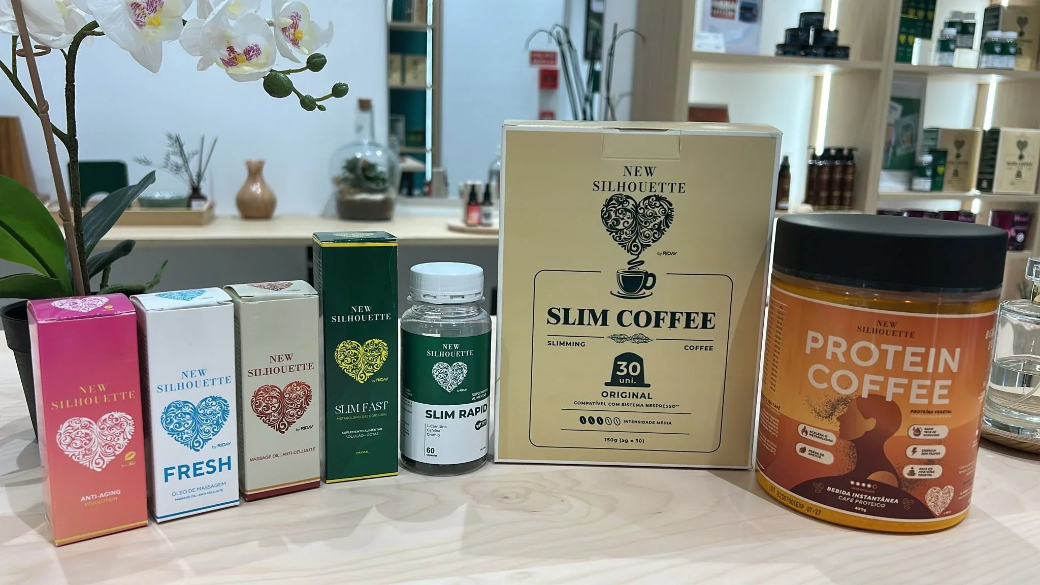 Produtos New Silhouette incluindo suplementos e cafés para emagrecimento em mesa de madeira